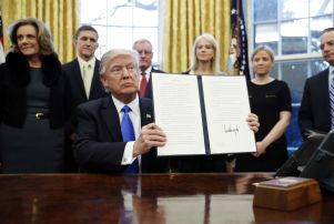 Copyright 2017 The Associated Press. All rights reserved. This material may not be published, broadcast, rewritten or redistributed without permission. Mandatory Credit: Photo by AP/REX/Shutterstock (8137008h) President Donald Trump holds up a signed Executive Order in the Oval Office of the White House, in Washington Trump, Washington, USA - 28 Jan 2017