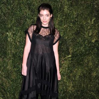 Lorde listens to new record through Apple earphones 